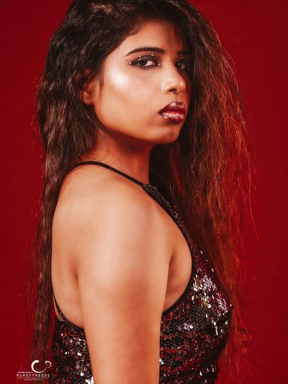 A classic profile shot that highlights her features against the rich red background.