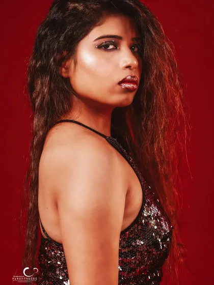 A classic profile shot that highlights her features against the rich red background.