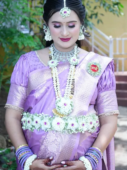 This photo beautifully captures the details of the necklace and kamarband, complete with an 'Aai' medallion pinned to her saree.