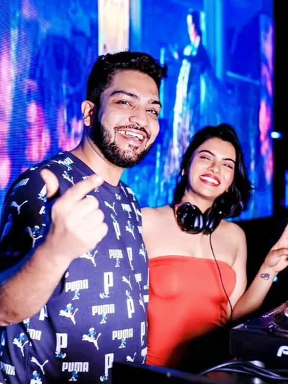 Posing with a fellow DJ behind the decks. Collaboration and sharing the stage with other talented artists is a big part of the nightlife scene.