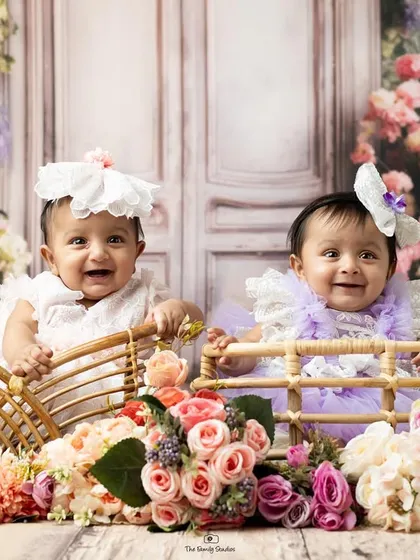 Another delightful shot of these twin babies during their floral-themed sitter session. Their happy expressions and cute outfits make for an unforgettable portrait.