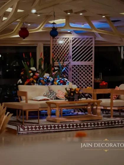 A comfortable and stylish lounge area for guests. The neutral-toned furniture is accented with colorful pillows and lanterns, set against a backdrop of geometric screens for a modern touch.