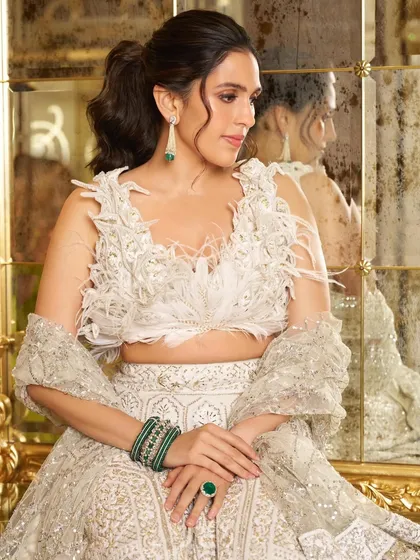A closer view of the feathered blouse and emerald jewelry, showing how to style this contemporary Manish Malhotra lehenga for a high-fashion look.
