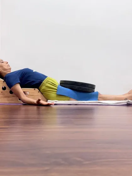 This is a demonstration of a supported Savasana using the Simhasana Box and weights. This restorative setup opens the chest to improve breathing, supports the natural curvature of the spine, and uses gentle weight to ground the body, calming the nervous system and promoting deep relaxation.