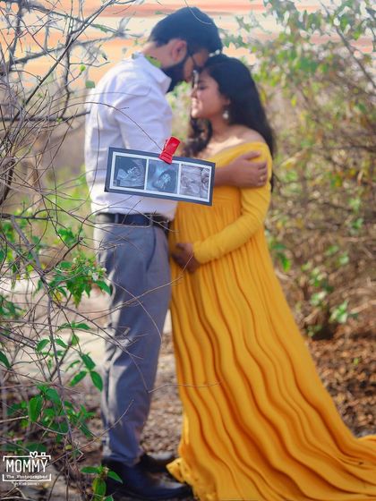 A kiss full of love and a peek at their little one. Incorporating the ultrasound photo into this outdoor couple's portrait makes the moment even more personal and heartfelt.