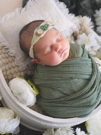 A slightly different angle of the baby nestled in the bowl, showing the layers of soft pillows and fabrics used to keep her comfortable.