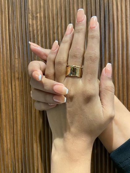 I love how the natural light hits these glossy French tips. It highlights the flawless application and the elegant shape of the nails.