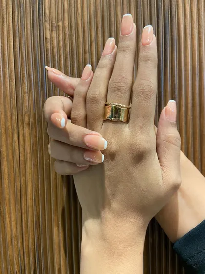 I love how the natural light hits these glossy French tips. It highlights the flawless application and the elegant shape of the nails.
