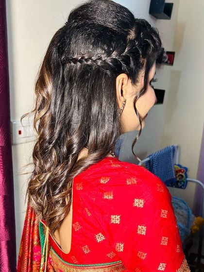 A back view of the Roka bride's hairstyle, showing the neat braid and curls.