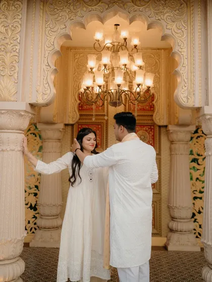A gentle touch and a shared secret. Posed against an ornate doorway, this image highlights the couple's connection amidst the splendor of their chosen royal location.