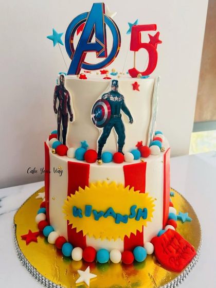 Avengers, assemble for a 5th birthday. This two-tier cake features Captain America and Iron Man, ready for action.