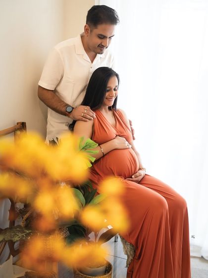 A peaceful moment for the expecting couple. The soft focus on the flowers in the foreground adds an artistic, layered look to the photograph.