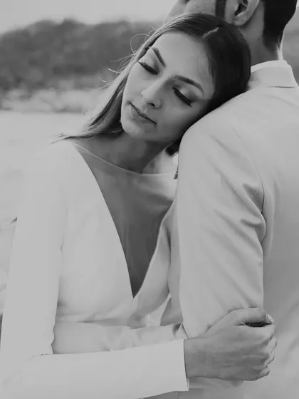 A serene and elegant black and white portrait from a pre-wedding shoot in Kashmir. The focus is on the quiet emotion and connection, set against a backdrop of natural beauty.