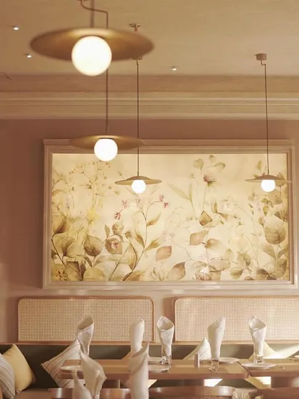 A large, framed floral mural in a restaurant, creating a soft, garden-like feel. The artwork, with its tones of beige, green, and blush, serves as a serene focal point.