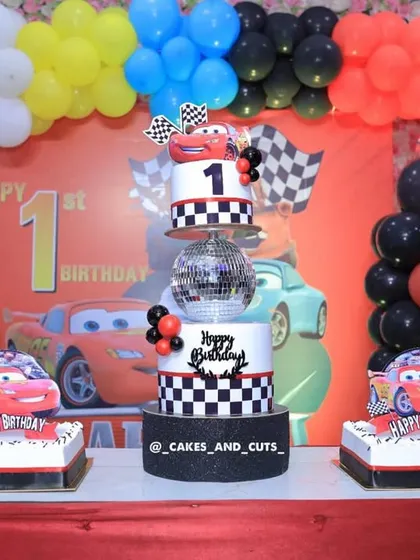 The full dessert table setup for the Cars-themed party, with the tiered cake flanked by two matching flat cakes.