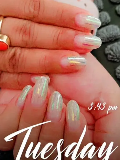 This is a holographic shattered glass effect on the nails. I used iridescent foil strips over a sheer white base to create a look that reflects a rainbow of colors.