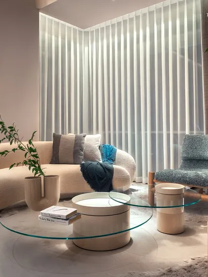 A serene seating nook within a Palais Royale bedroom, where a curved sofa and textured armchair create a moment of pause. The design balances openness with intimacy, speaking directly to those who savor luxury yet crave minimalism.