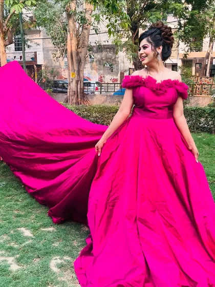 Three angles of our vibrant magenta off-shoulder gown with a long trail. These photos showcase its stunning color and dramatic flair, perfect for outdoor pre-wedding shoots.