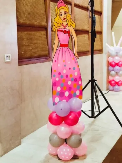 A full-length Barbie character cutout on a pink, purple, and grey balloon base.