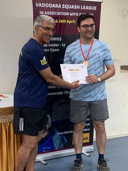 A participant receiving his certificate and medal at the Vadodara Squash League.