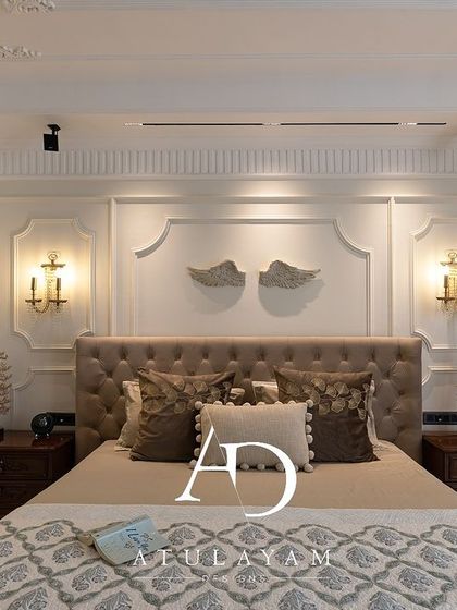 A frontal view of the bed in the classical room, showcasing the symmetrical design, wall-mounted angel wings art, and plush bedding.