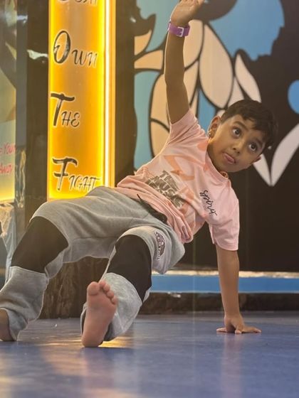 This young dancer shows off a cool hip-hop move. Our classes give kids the freedom to develop their own style while learning foundational dance techniques.