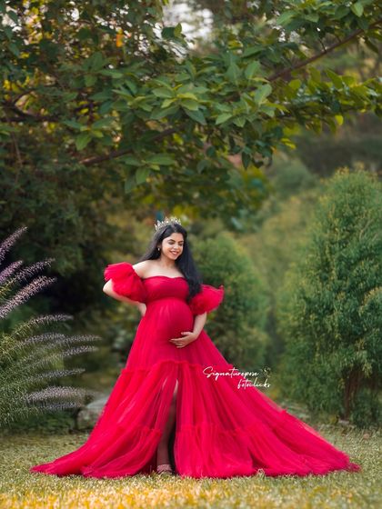 Surrounded by lush greenery, this portrait in a stunning red gown feels both powerful and serene.