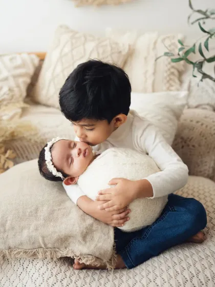 A sweet kiss from a big brother to his newborn sister. These are the moments I love to capture during a newborn with sibling photoshoot.