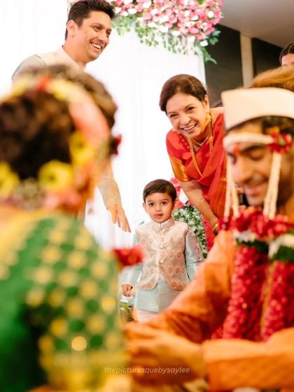 A heartwarming scene with family members looking on with joy as the couple participates in the wedding rituals.