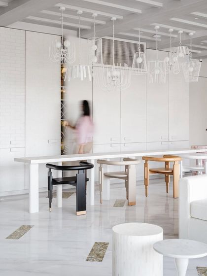 The prohibition-era-esque bar in House No. 7 is blended seamlessly into the wall. The mismatched chairs at the long dining table add an eclectic, collected feel.
