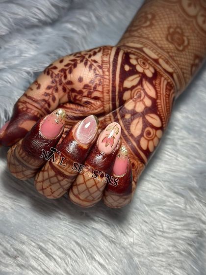 This close-up shows the delicate lotus flower design, a popular request for bridal nails, created with chrome for a modern touch.