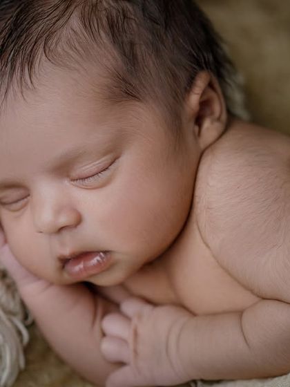 The beauty of sleep. This close-up shot in neutral tones focuses on the baby's perfect, peaceful face as they rest.