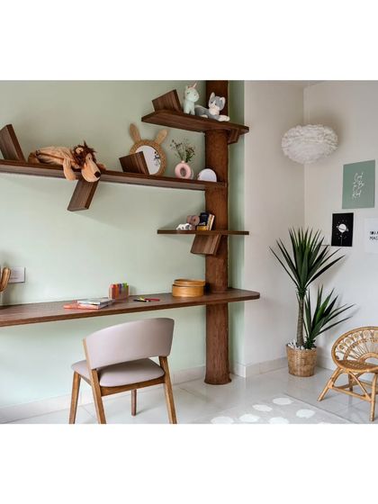 The study area in the kids' room features a custom tree-shaped desk and shelving unit. It’s a whimsical design meant to inspire creativity and make homework a little more fun.