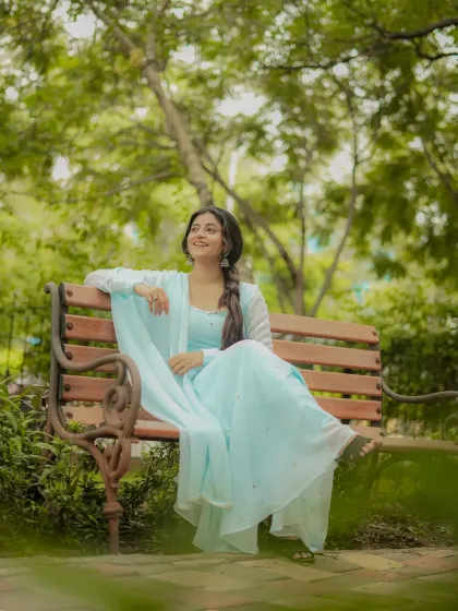 A wider shot that shows more of the flowing outfit and the peaceful park setting.