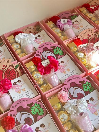 A beautiful array of bridesmaid hampers, each containing Ferrero Rocher, a shot glass, a face sheet mask, and a custom scrunchie.
