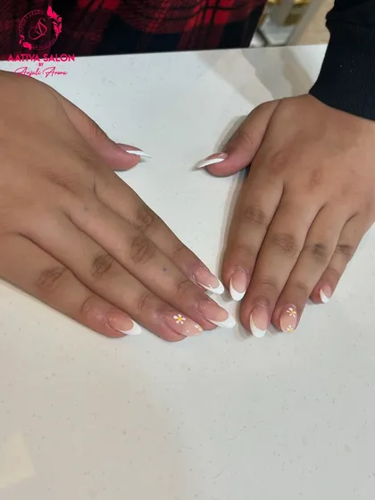 The perfect combination of classic and cute. These French-tipped nails with small floral accents are a client favorite for a reason.