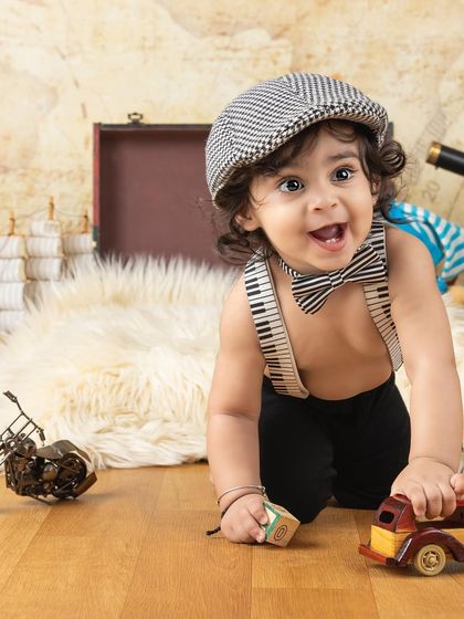 This little explorer with his vintage cap and toy car is ready for an adventure.
