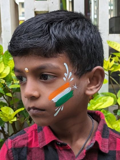 A patriotic design for Independence Day, featuring the Indian flag painted on a child's cheek.
