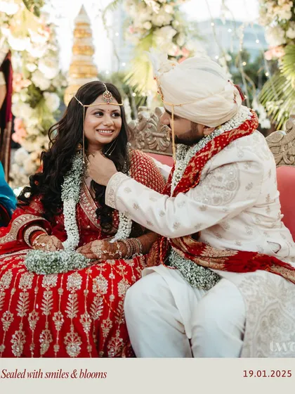 "Sealed with smiles & blooms." A tender moment during the wedding rituals, capturing the groom's affection for his bride.