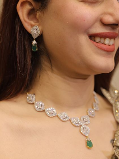 A classic diamond-look necklace with a single emerald drop. This piece is versatile and can be paired with both traditional and contemporary outfits.