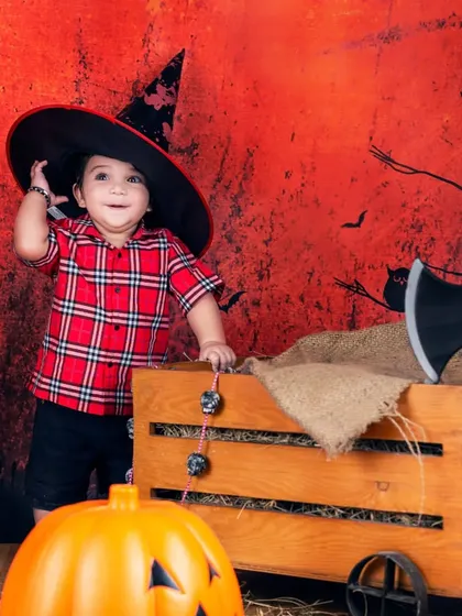 This little witch is having a great time in our spooky Halloween setup, complete with a cauldron and bats.