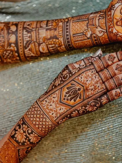 A close-up of the intricate lotus and geometric patterns on the back of the hand. The dark stain makes the design look incredibly rich.