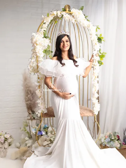 A fairytale moment in a golden birdcage adorned with white flowers. This whimsical setup creates a romantic and enchanting scene, perfect for a mom-to-be who loves a touch of fantasy.
