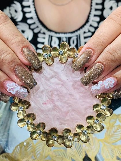 This design combines a rich, glittery brown polish with accent nails featuring delicate 3D white flowers. It's a great example of a balanced and elegant embellished set.