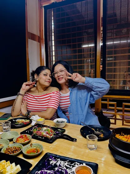 A happy moment with a friend at a Korean restaurant, sharing food and making memories.