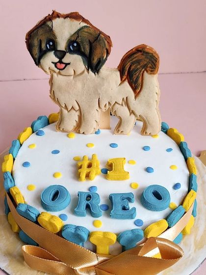 A custom cake for Oreo the Shih Tzu, featuring a hand-drawn cookie topper that looks just like him. We can create toppers for any breed.