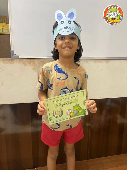 Another proud camper showing off his bunny ears and his summer camp diploma. A double dose of accomplishment.