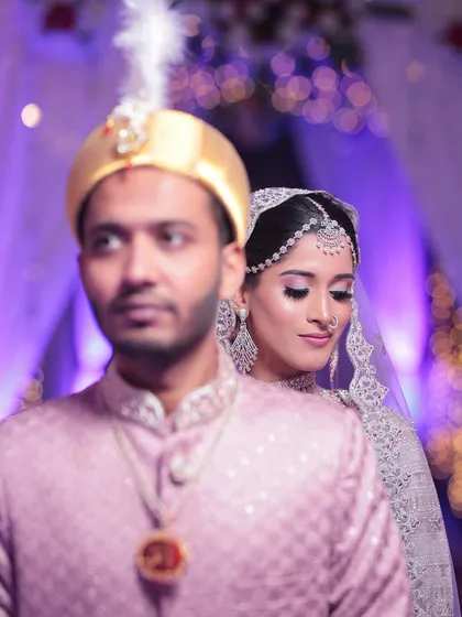 An artistic shot of the bride and groom. The focus on the bride's serene expression highlights her flawless makeup and the sparkle of her diamond jewellery.