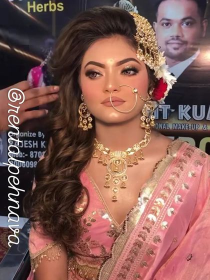 A model getting her hair styled while wearing a pink bridal lehenga, showing a glimpse of the getting-ready process.