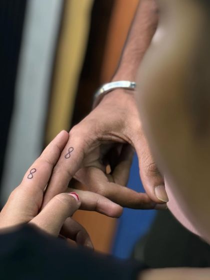 The process of creating matching infinity symbol finger tattoos. We take care to ensure even the smallest designs are perfectly placed.